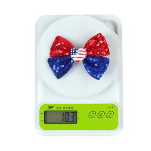 Détail du nœud papillon à paillettes rouge et bleu pesant 10,3g sur une balance