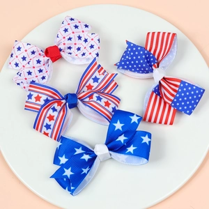 Close-up of four American flag style bow clips with patriotic stars and stripes patterns