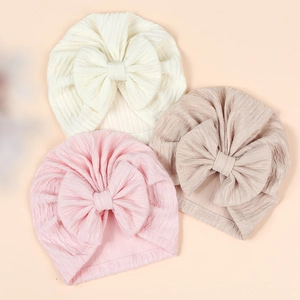 Soft ribbed baby bow turban hats in white, pink, and brown colors for infants