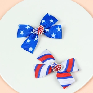 Macro detail of USA flag pattern bow hair clips with sparkling rhinestone heart accents