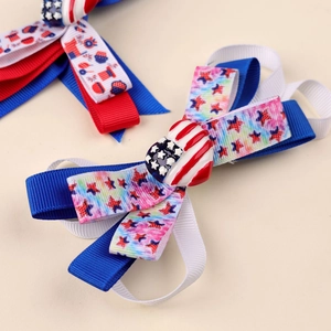 Close-up of Independence Day hair bow with red white and blue ribbons and heart flag charm