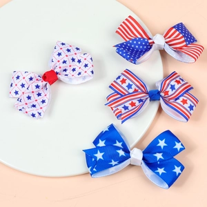 Detail view of 4-piece American flag bow hair clips set made from grosgrain ribbon on ceramic