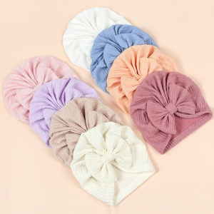 Detail of 8 assorted colors infant bow turban hats in soft ribbed knit fabric texture