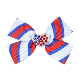 Close-up of a striped bow hair clip with a sparkling heart-shaped rhinestone center