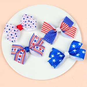 Close-up of four American flag patriotic hair bows on a white circular display tray