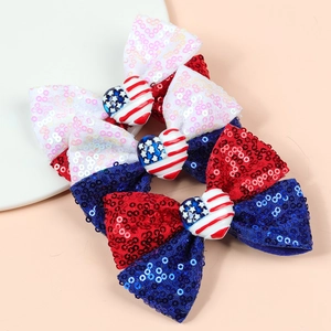 Détail de trois nœuds à cheveux à paillettes avec décors patriotiques en forme de cœur