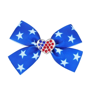 Detail of blue grosgrain bow hair clip with white stars and a rhinestone heart buckle