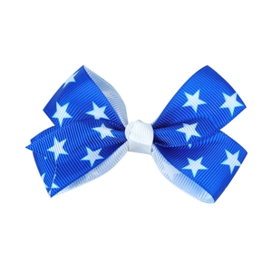 Detail of blue grosgrain bow hair clip featuring a white star pattern and ribbed texture