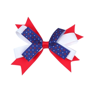 Detail of red white and blue layered ribbon hair bow with patriotic star and polka dot patterns