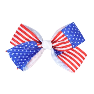 Close-up of patriotic American flag ribbon bow hair clip with red white and blue stars