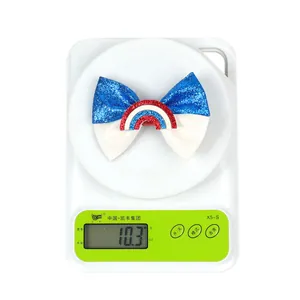 Digital scale showing the weight of a patriotic bow hair clip at 10.3g for children
