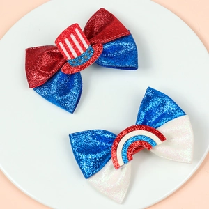 Close-up of glitter Independence Day hair bows with stars, stripes, and rainbow decor