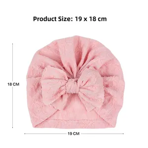 Detail view of pink baby turban hat featuring jacquard texture and large bow decoration