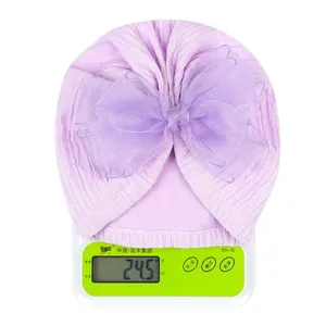 Detailed view of lightweight lilac baby turban hat showing 24.5g weight on a scale