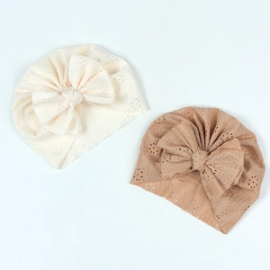 Détail de bonnets turbans pour bébé avec grands nœuds et texture tricotée ajourée