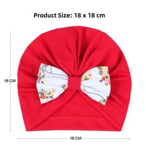 Détail du turban rouge pour bébé avec nœud floral, dimensions 18 x 18 cm sur fond blanc