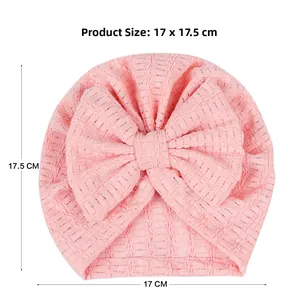 Bonnet turban rose pour nouveau-né avec nœud et texture gaufrée douce tricotée