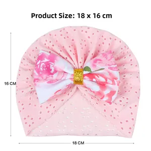 Pink newborn turban hat with mesh texture and floral bow measuring 18 x 16 cm