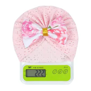 Pink newborn baby turban hat with eyelet fabric and floral bow, weighing 22.2 grams