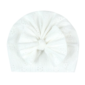 Bonnet blanc en dentelle ajourée pour bébé avec un grand nœud décoratif pour nouveau-nés