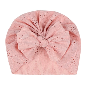 Détails de la texture du bonnet turban rose pour bébé en dentelle avec grand nœud