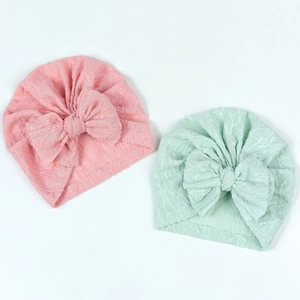Detail of baby turban hats with bow in pink and mint green jacquard texture