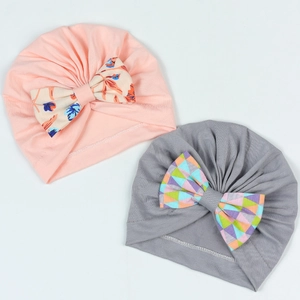 Détail de bonnets pour bébé avec nœuds floraux et texture en maille plissée