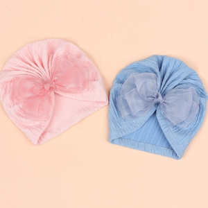Detailed knit texture and layered mesh bows on pink and blue baby turban hats