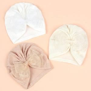 Detailed close-up of ribbed knit baby turbans featuring large organza bows in soft pastel tones