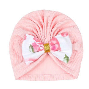 Pink rib knit infant turban hat with a large floral print bow and glitter gold center