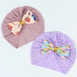 Detail of newborn turban hats with floral bows and breathable hollow mesh fabric texture