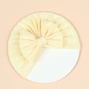 Détail d'un turban nouveau-né jaune pâle en maille texturée avec un grand nœud décoratif