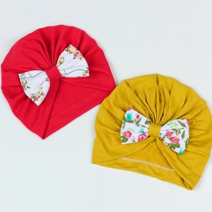 Lot de deux bonnets pour bébé en rouge et jaune moutarde avec nœuds à fleurs