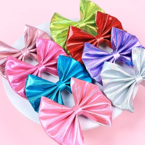 Set of 8 shiny leather hair bows for girls in metallic vibrant colors on a white plate
