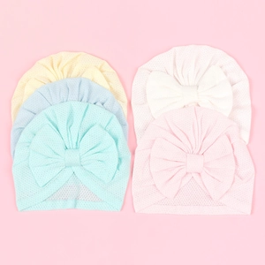 Detail view of five breathable mesh baby turban hats with large bows in pastel colors