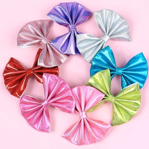 Detailed view of eight glossy metallic bow hair clips in various vibrant colors