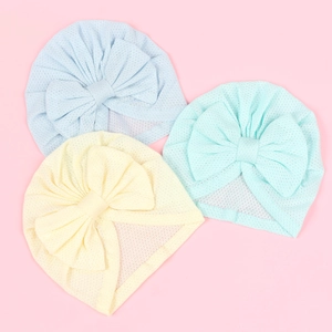 Three-pack mesh baby turban hats in pastel blue, yellow and mint green with large bows
