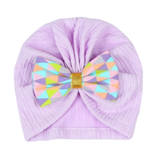 Detail of lavender baby turban hat with colorful geometric bow and gold glitter center