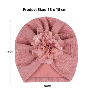 Pink infant turban hat with gold dot floral detail and 18x18 cm size specifications