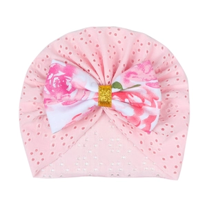 Pink newborn turban hat with floral bow and breathable eyelet fabric for baby girls