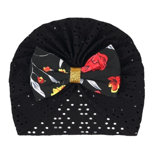 Detail of breathable hollow mesh newborn turban hat with floral bow and gold sequins