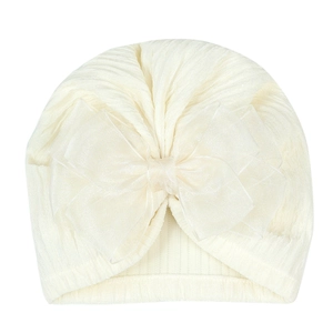 Detailed texture of off-white ribbed knit baby turban hat with oversized organza bow