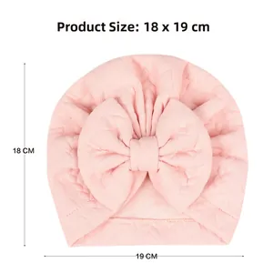 Pink waffle fabric baby turban hat with bow detail showing product size 18 x 19 cm