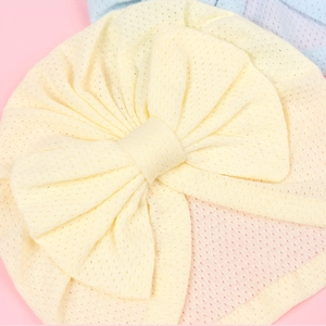 Close-up of baby mesh breathable hat with a large decorative bow in light yellow