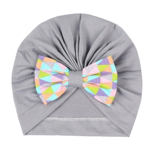 Détail du bonnet turban gris pour bébé avec un nœud papillon à motifs géométriques