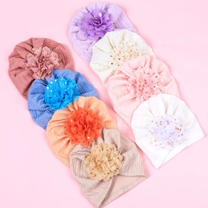 Flat lay view showing eight colors of baby turbans with decorative gold glitter flowers