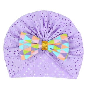 Close-up of lavender newborn turban hat with a colorful geometric pattern bow detail