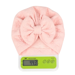 Detailed view of pink baby turban hat weighing 44.3g with textured bow design