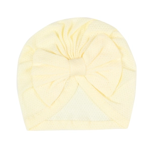 Close-up of pale yellow infant turban hat featuring breathable mesh fabric and a large bow