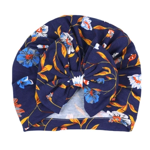 Detailansicht der dunkelblauen Baby-Turbanmütze mit Blumenmuster und großer Schleife